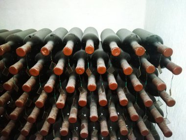 Şarap mahzenlerinde raflarda tozlu şarap şişeleri