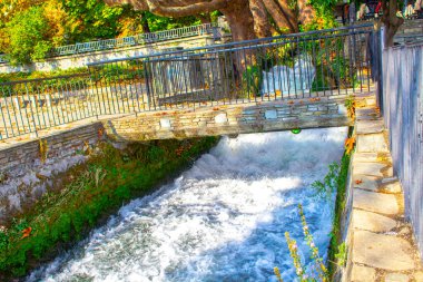 Doğal parktaki nehrin üzerindeki eski taş köprü. Güzel çağlayan şelale 