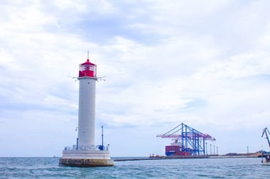 Güzel manzara. Mevcut deniz feneri. Odessa 'daki Vorontsov deniz fenerine karşı Karadeniz' in arka planı, yakın plan. Üzerinde mavi deniz manzaralı kırmızı bir kabin olan beyaz kule.