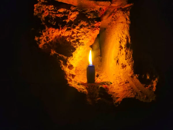 Eine Brennende Kerze Vor Verschwommenem Backsteinhintergrund — Stockfoto
