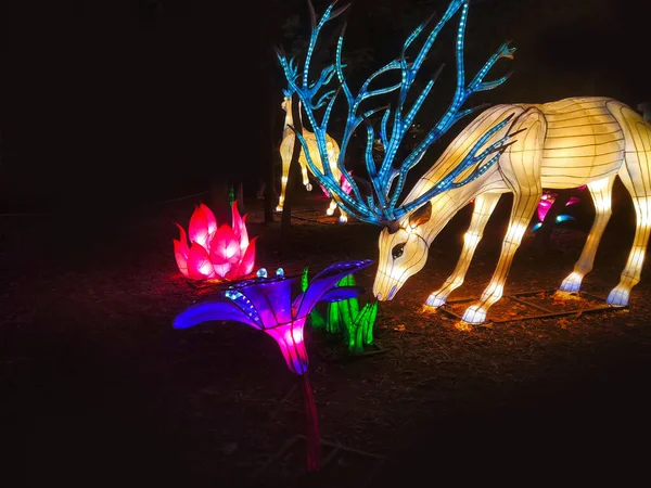 Santa's deer made of strip light as a Christmas decoration. Garden decorated with the glittering lights and luminous deer.
