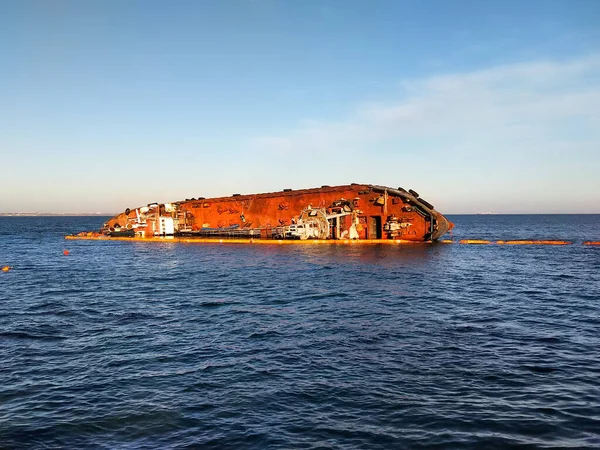 Closeup sunken tanker. Ship through after storm ashore. The tanker lies on its side.