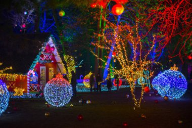 Noel ışıkları müesseseden. Çatının altında asılı sarı, kırmızı, turuncu ampullerden oluşan su geçirmez güzel bir çelenk. Parlayan güzel Noel ağaçları