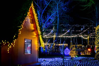 Noel ışıkları müesseseden. Çatının altında asılı sarı, kırmızı, turuncu ampullerden oluşan su geçirmez güzel bir çelenk. Parlayan güzel Noel ağaçları