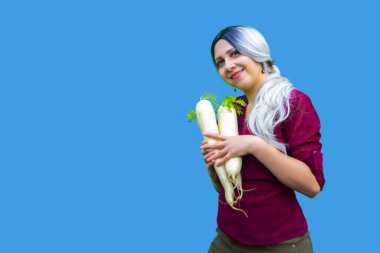 Olgun daikon turpuna yakın, organik yeşil sebze yetiştiren kadın, sağlıklı beslenme konsepti, elinde yiyecek tutan kadın.