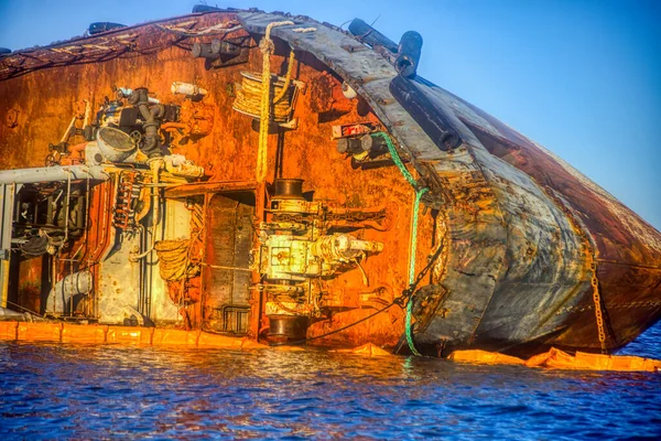 Closeup sunken tanker. Ship through after storm ashore. The tanker lies on its side.