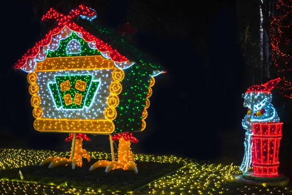 a hut on chicken legs, glowing trees, figures on a city park