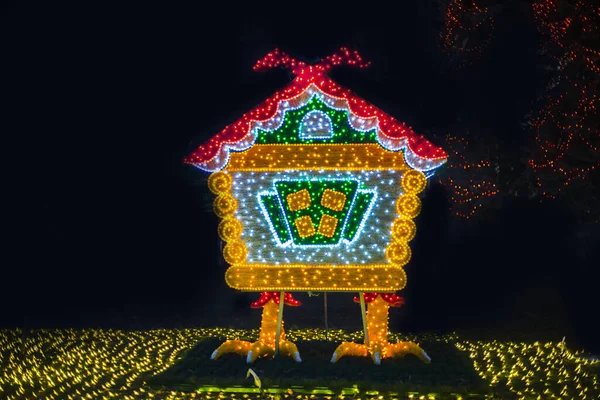 a hut on chicken legs, glowing trees, figures on a city park