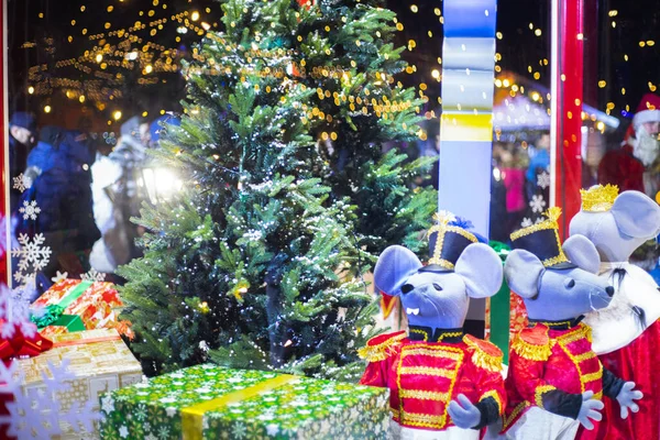 Christmas toy mouse, a symbol of the Chinese New Year. soft toy mouse stands near a gift bag