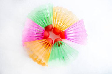 Çok renkli badminton toplarını beyaz arka plana yerleştir. Düz yatıyordu. Minimalizm. Spor, fitness, sağlıklı yaşam tarzı ve nesneler konsepti