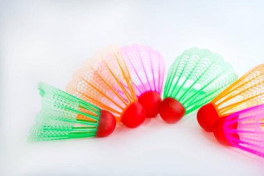 Çok renkli badminton toplarını beyaz arka plana yerleştir. Düz yatıyordu. Minimalizm. Spor, fitness, sağlıklı yaşam tarzı ve nesneler konsepti