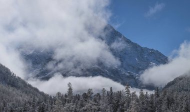 karla kaplı dağ zirveleri bulutlar