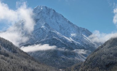 karla kaplı dağ zirveleri bulutlar