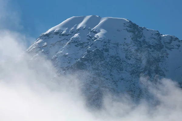 Sommets enneigés des montagnes dans les nuages — Photo