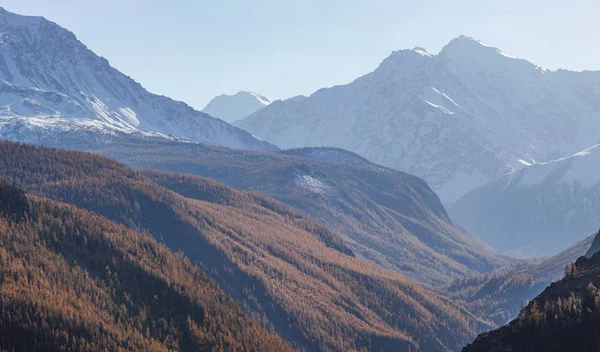 Mountain gorge and snow-capped peaks in a blue haze