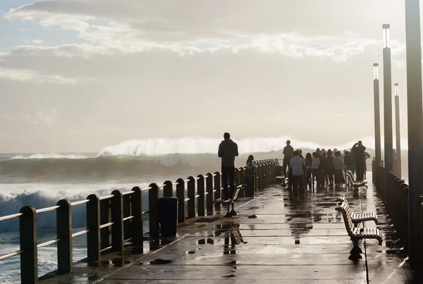 Люди пляжа Пирс волны — стоковое фото