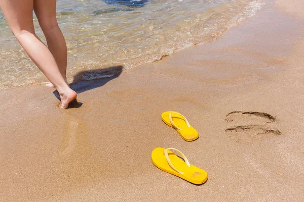 Spiaggia ragazza gambe pantofole gialle — Foto Stock