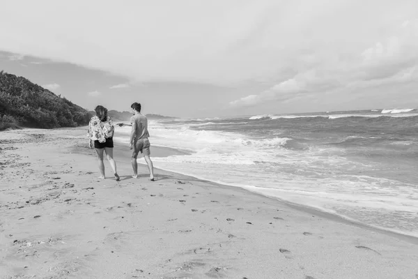 Друзья, гуляющие по пляжу океана — стоковое фото