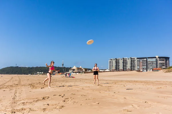 Adolescentes playa frisbee lanzar — Foto de Stock