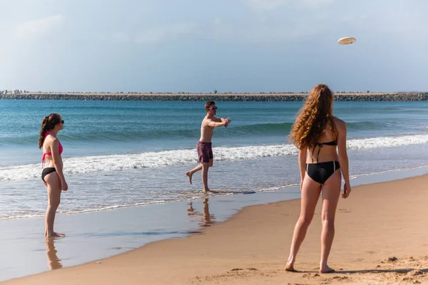 Adolescentes playa frisby lanzando — Foto de Stock