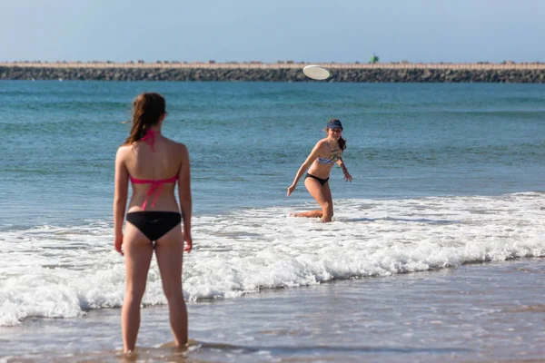 Adolescentes playa frisby lanzando —  Fotos de Stock