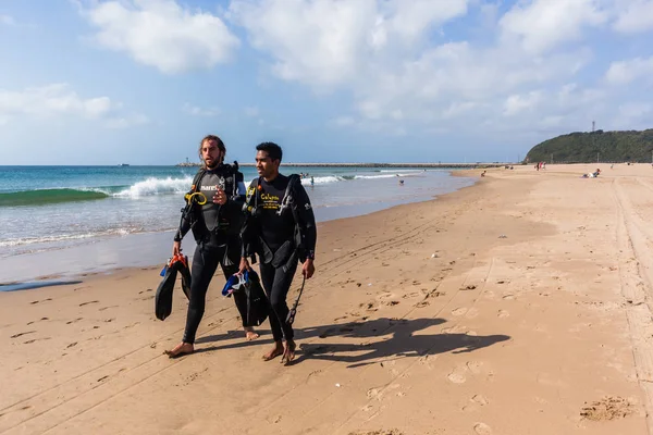 Buceadores caminando por la playa — Foto de Stock