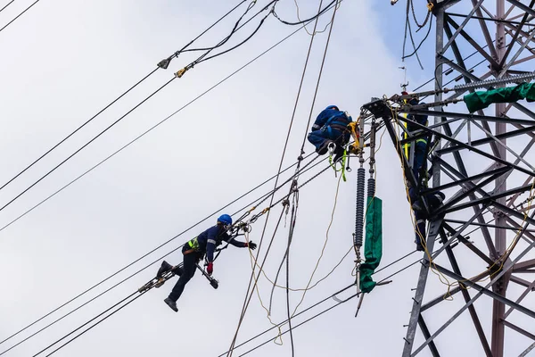 電気技師の鉄塔送電線修理 — ストック写真