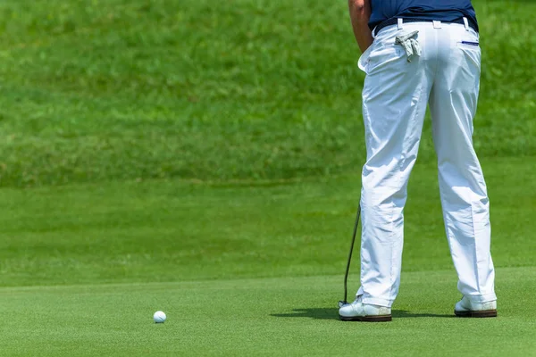 Golfista zelené uvedení míč zadní — Stock fotografie