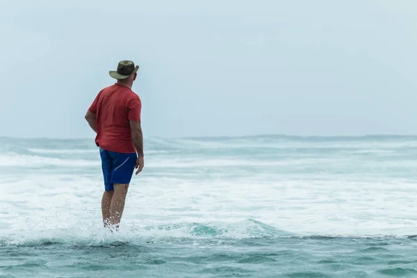Mannen tidvatten Pool vägg titta på havet — Stockfoto