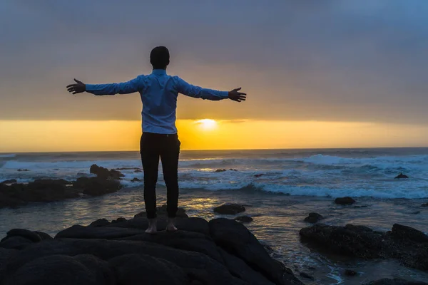 Man Arms Wide Beach Ocean Rocks Silhouetted — Stock Photo, Image