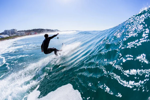 冲浪者的侧写滑行海浪后的动作在游泳的水面照片后面 — 图库照片