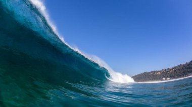 Okyanus dalgası, içi boş su borularına çarpıyor. Panoramik mavi manzara..