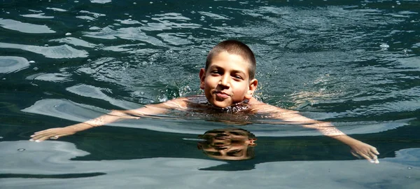 息子はミルスタット湖 カリンシアの澄んだ海で泳いでいます — ストック写真