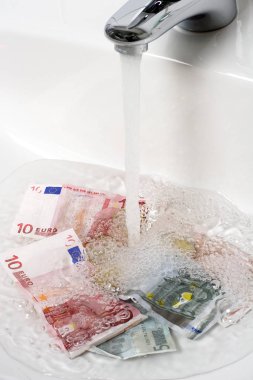 money laundering money is washed under running water clipart