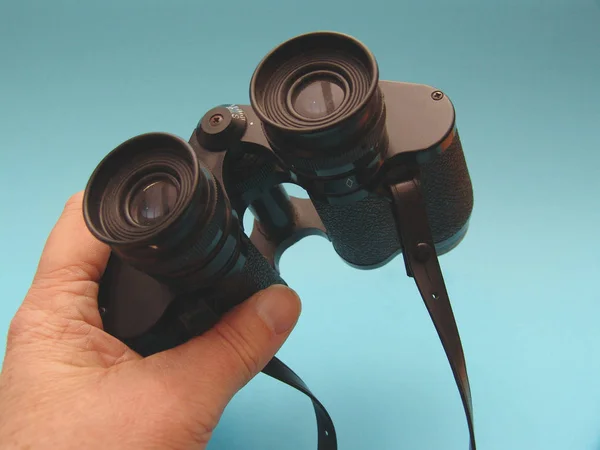 Man Holds Binoculars Blue Background — Stock Photo, Image