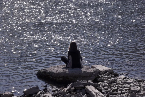 Νεαρή Γυναίκα Που Κάθεται Στα Βράχια Στη Θάλασσα — Φωτογραφία Αρχείου