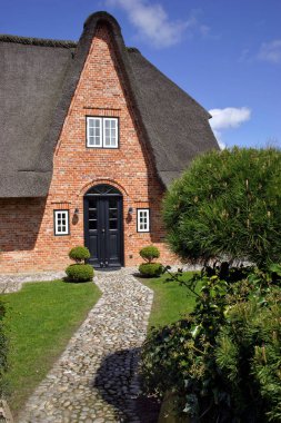 a pointed thatched roof in kampen on sylt clipart