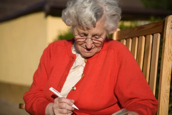 Yaşlı Bir Kadın Sandalyeye Oturur Bir Şeyler Yazar Bir Gizemi — Stok fotoğraf