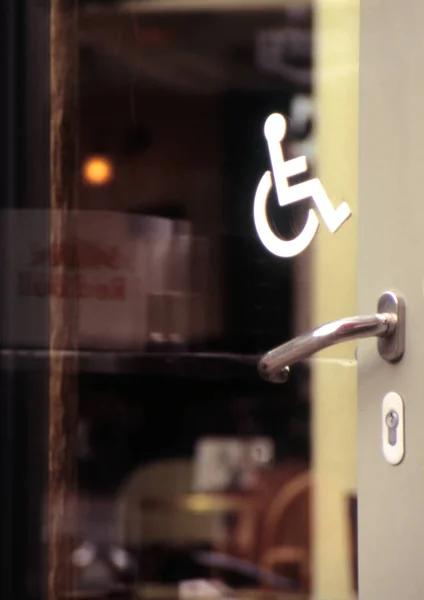 Zbliżenie Szklanych Drzwi Symbolem Wózka Inwalidzkiego — Zdjęcie stockowe