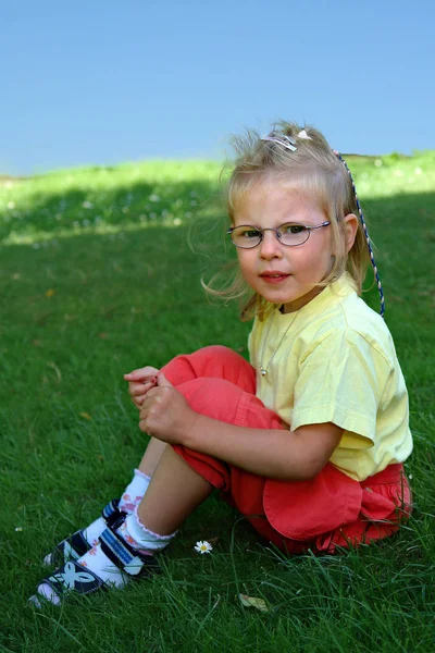 3岁的女孩坐在草地上 — 图库照片