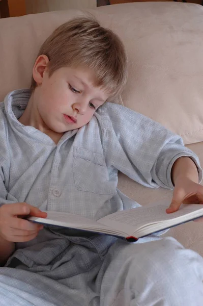 Liten Pojke Läser Bok Sängen — Stockfoto