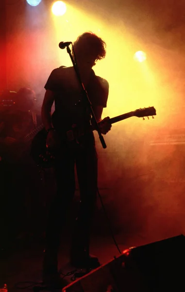 ステージにギターを持った男のシルエットが — ストック写真