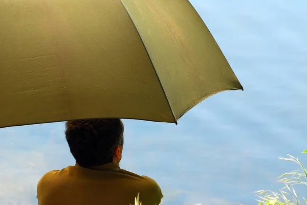海岸に傘を差した男の後ろ姿 — ストック写真