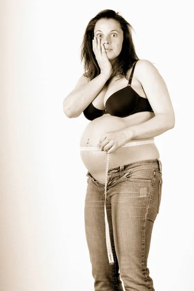 お腹に手を置いて妊娠中の女性は — ストック写真