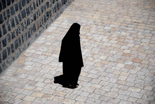 黒いドレスを着た女性が通りを歩いていて — ストック写真