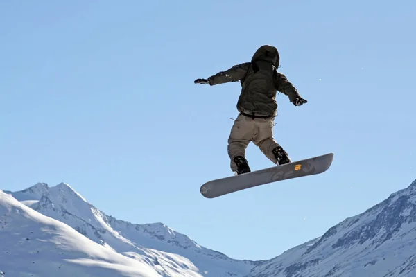 Snowboarder Saltando Montanhas Nevadas — Fotografia de Stock