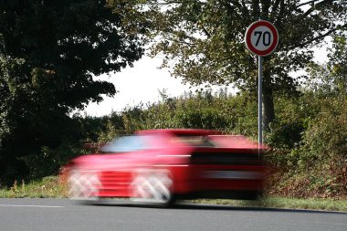 a red car on a road clipart