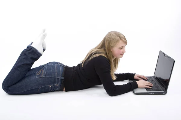 床にノートパソコンを使っている若い女性は — ストック写真