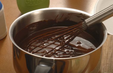 whisk in pan with melted chocolate clipart
