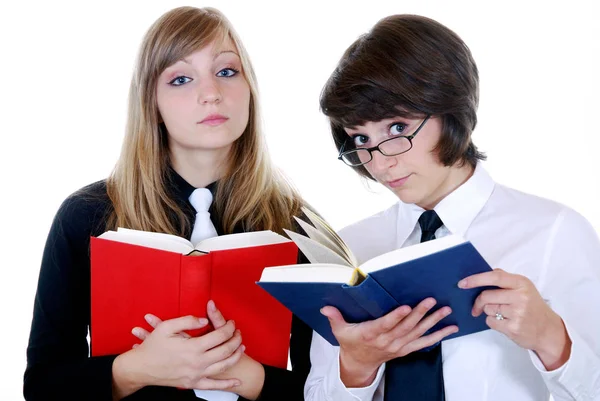 两个拿着书本和眼镜的年轻女子 免版税图库照片